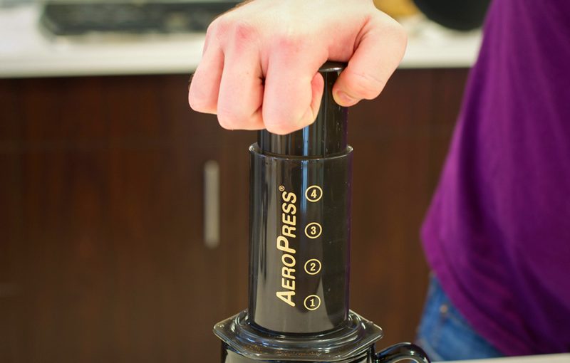 Pushing the plunger of an AeroPress coffee maker