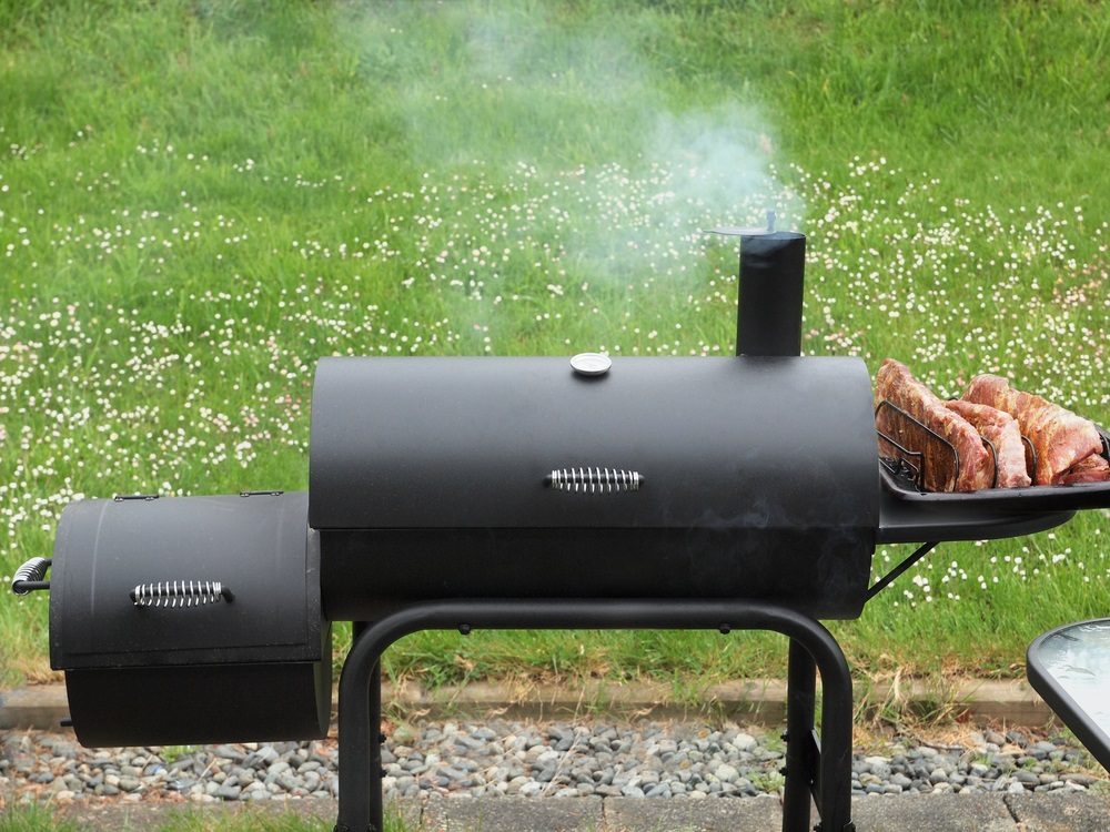 Charcoal offset smoker during backyard cookout