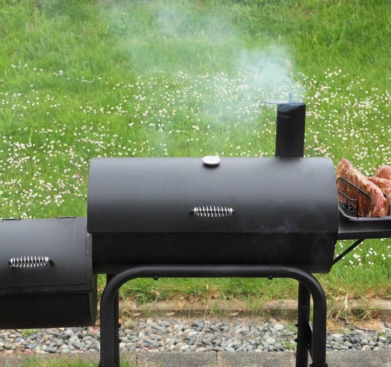 Charcoal offset smoker during backyard cookout