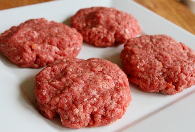 Raw hamburger patties on a plate