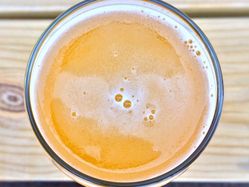 Top-down angle of a glass of beer on a table.