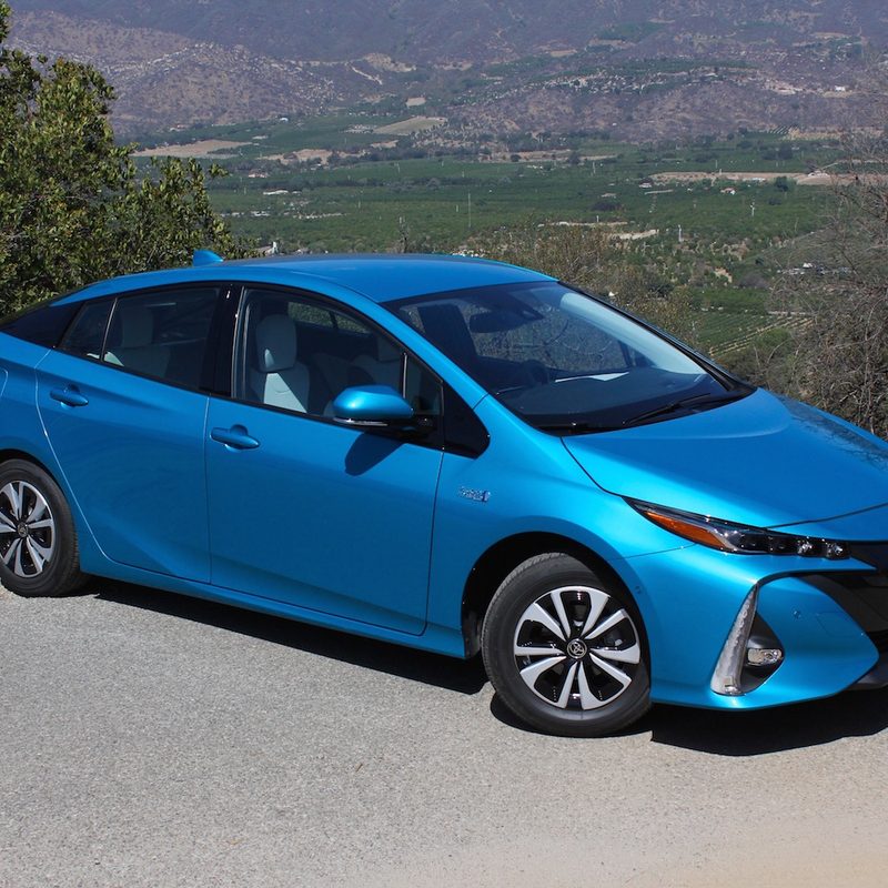 2017 Toyota Prius Prime parked on the side of a road in front of a hill.