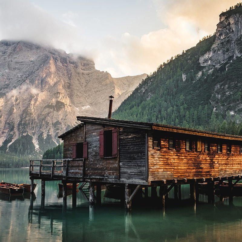 Cabin in the woods with mountains in the background.