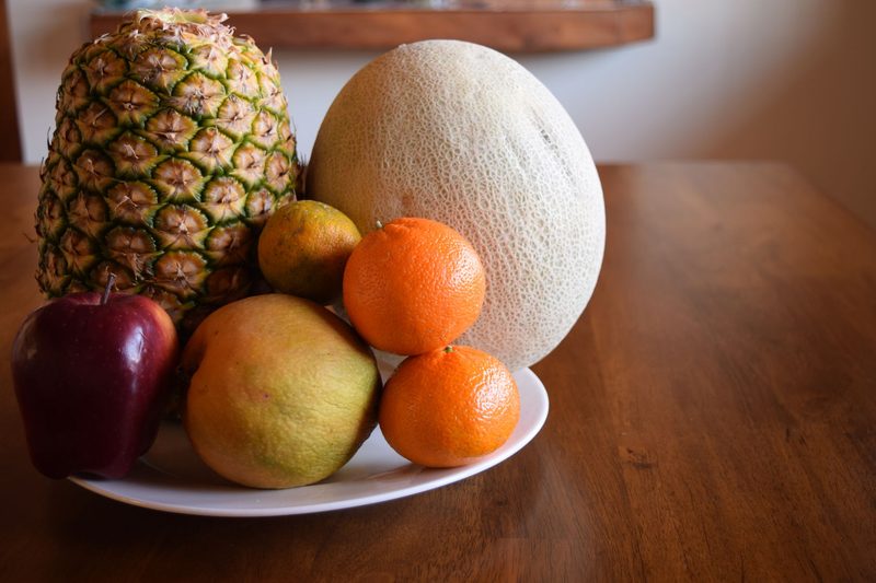 55019841 - the tropical fruits and odd apple all together on a wooden table