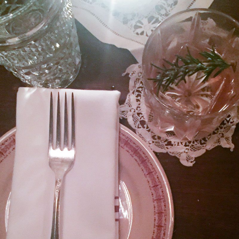 Place setting with fork, napkin, and rosemary cocktail