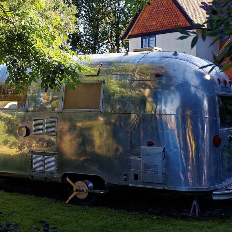 Airstream trailer parked outside cottage