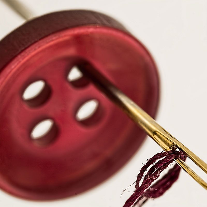 Red button with needle going through