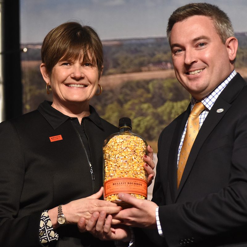 bulleit distilling new distllery ribbon cutting ag commissioner ryan quarlespresents dierdra mahlan with gift crop