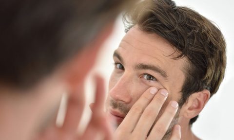 Stock-Man-Looking-in-Mirror-at-Skin