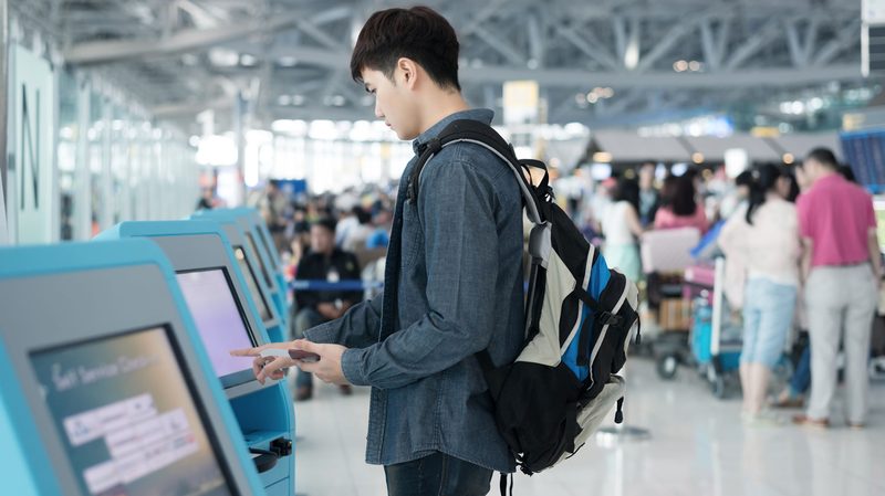 facial recognition, Stock-Man-Printing-Boarding-Pass-at-Kiosk