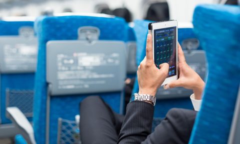 Man using his phone on an airplane.