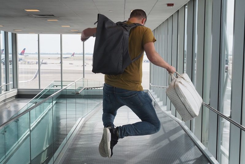 the points guy, man leaping into air, airport