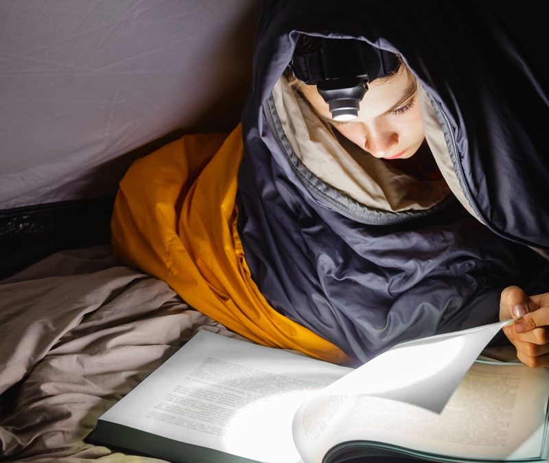 boy-in-tent-with-headlamp-and-sleeping-bag-on