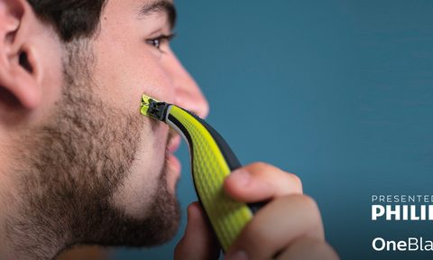 philips OneBlade razor in use against blue background