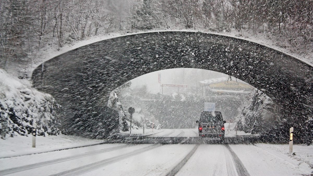 Car in the snow under an overpass