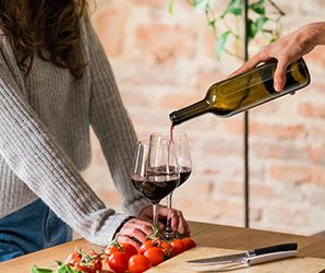 Woman being poured red wine.