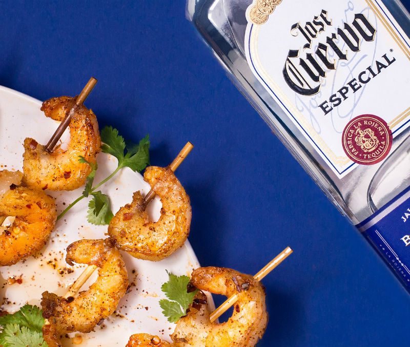Jose Cuervo tequila with a plate of shrimps on the side.