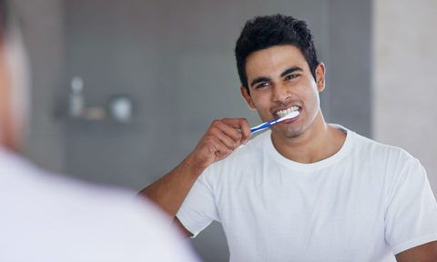 man brushing teeth bathroom