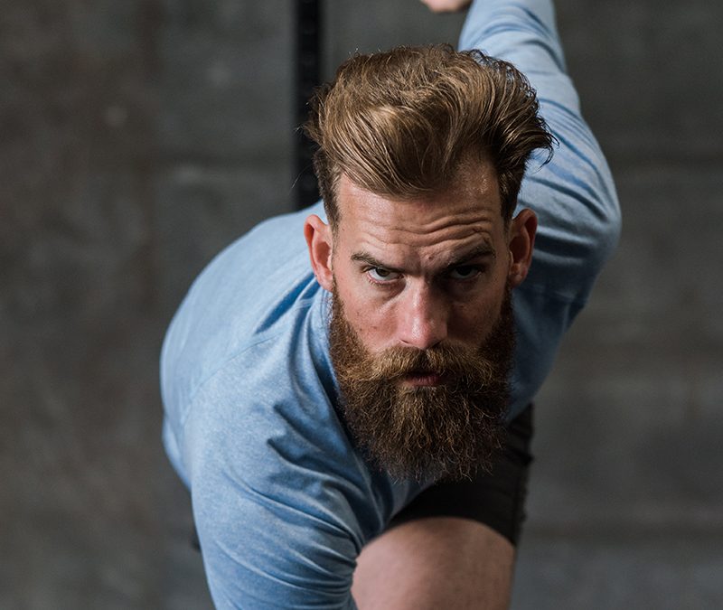 Bearded man looking confidently at the camera in a runner's starting position.