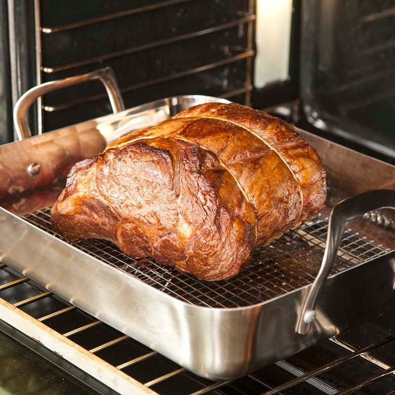 prime rib in a roasting pan sitting on the oven rack.
