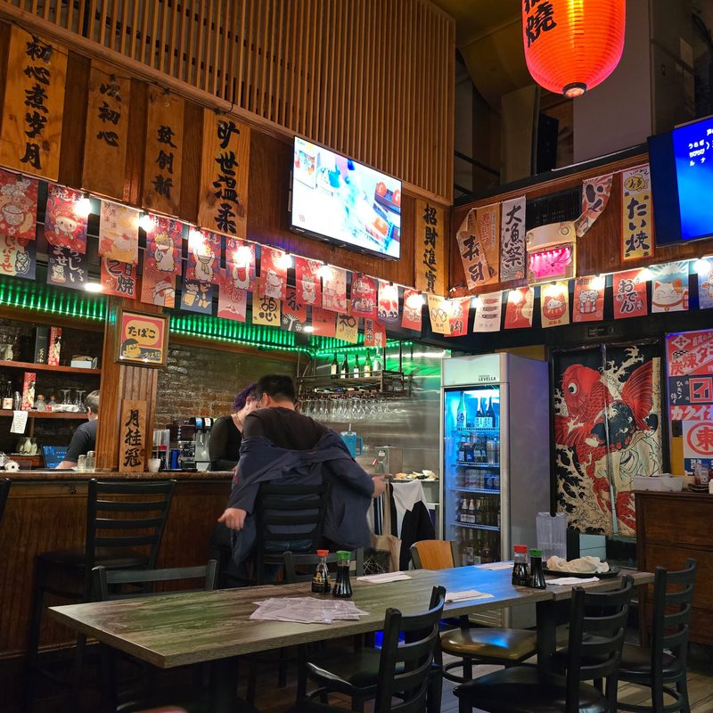 The bar and seating area at Nami Japanese Restaurant featuring Japanese decor and stylish lighting