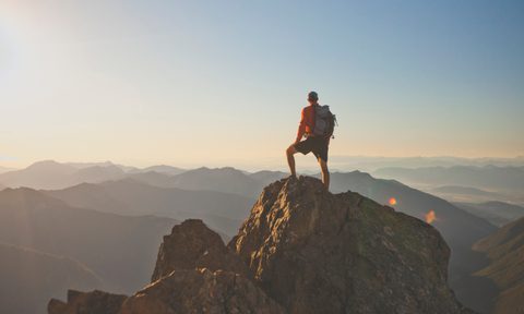 best hiking shoes for men photograph of adventurous backpacker standing on mountain peak  north cascades national park washin