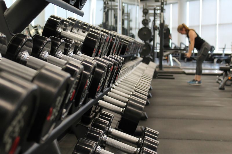 Dumbbell weights on a gym rack in a gym.
