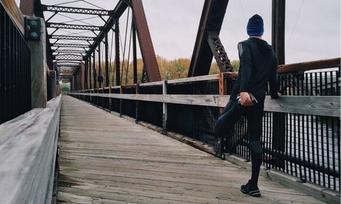Man stretching during his cool-weather run