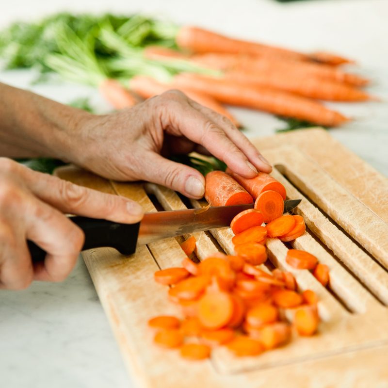 man cutting carrots