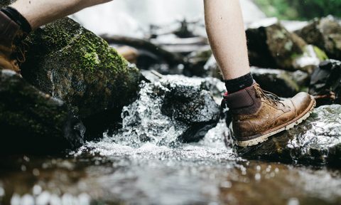 Person with hiking boots walking through water