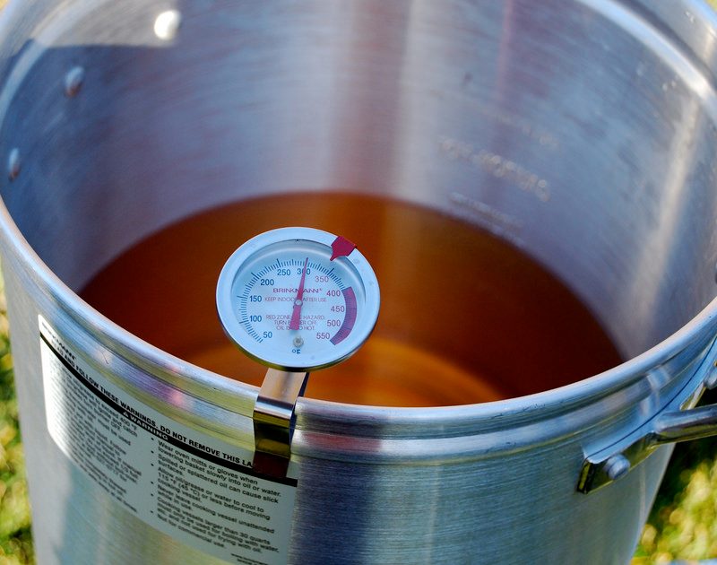Stock pot and temperature gauge placed on a grassy terrain