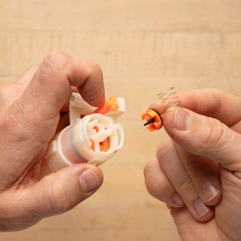 A pair of hands removes the orange cap and spring of the Hammershot.