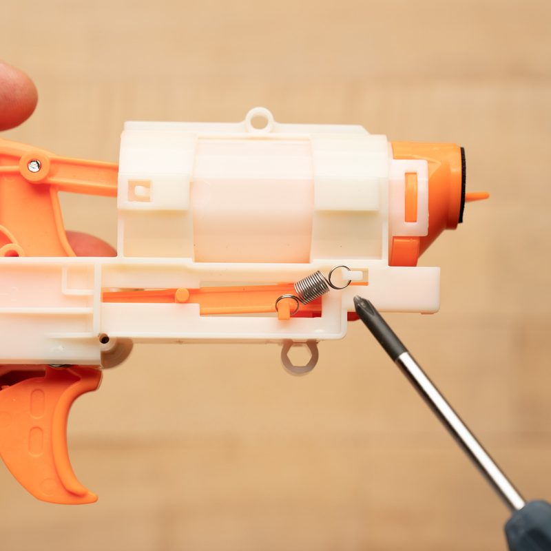 A close-up of a spring and a screwdriver.