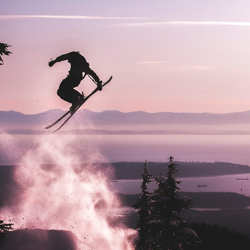 Silhouette of a skier jumping high in the air.