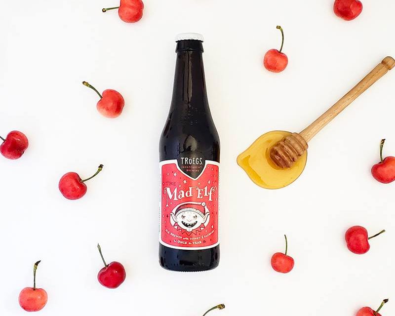Mad Elf beer surrounded by cherries.