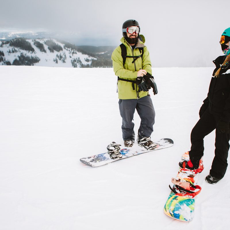 A man and woman on snowboards