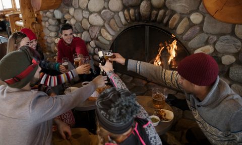Group of friends gathering in front of a fireplace.