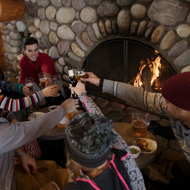 Group of friends gathering in front of a fireplace.