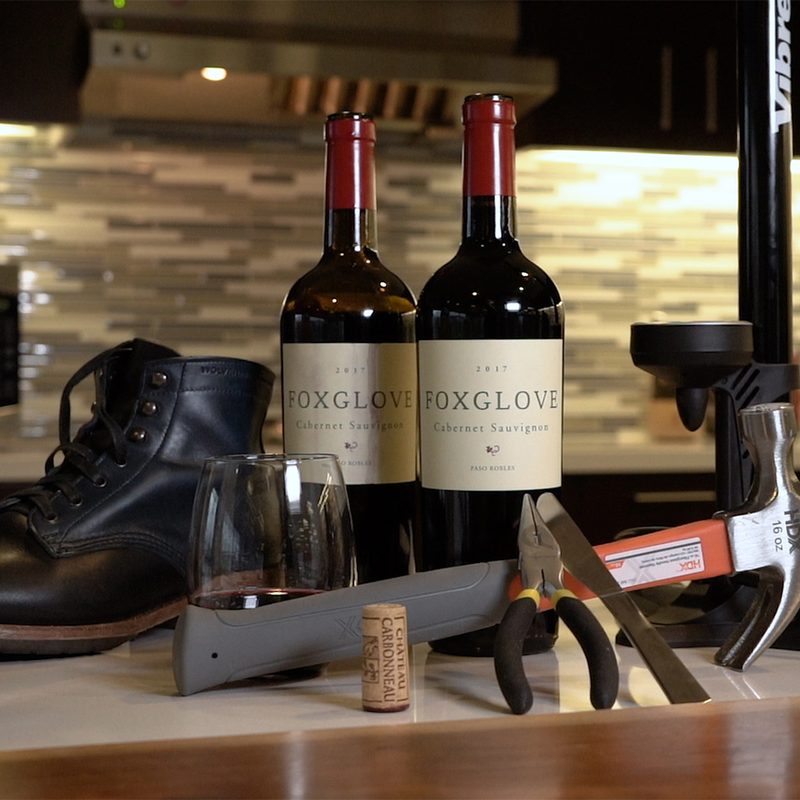 Wine bottles sitting with some opening tools