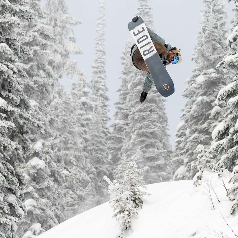 Snowboarder catching air on a Ride brand snowboard.