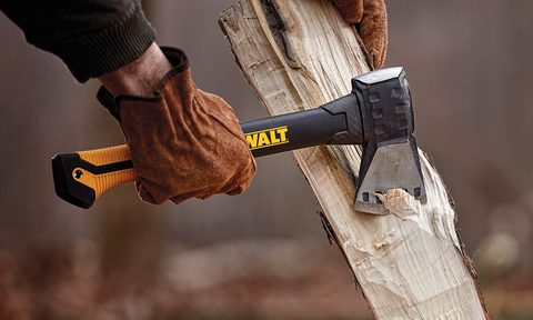 A man wearing leather gloves using a Dewalt axe chopping wood