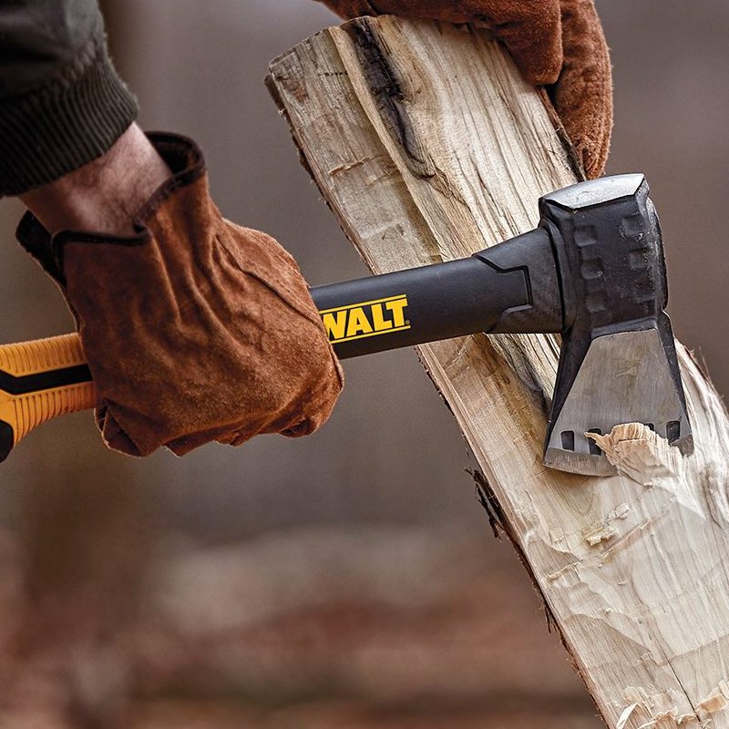 A man wearing leather gloves using a Dewalt axe chopping wood