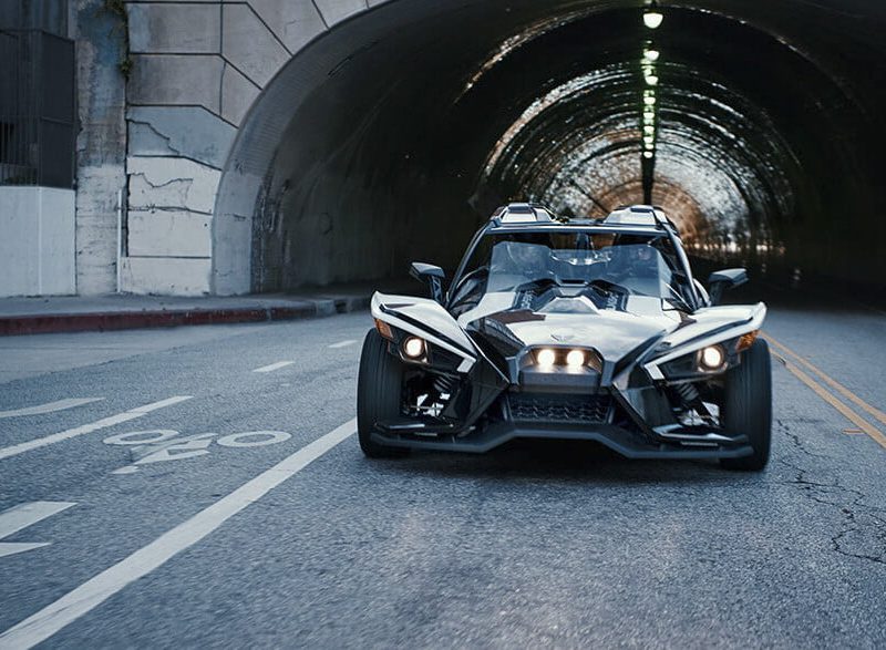 Polaris Slingshot Grand Touring Autocycle racing out of a tunnel toward the camera.
