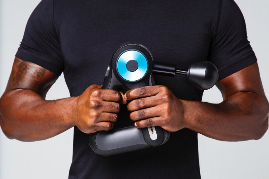 theragun g3pro percussive therapy theargun pro man holding in front of chest