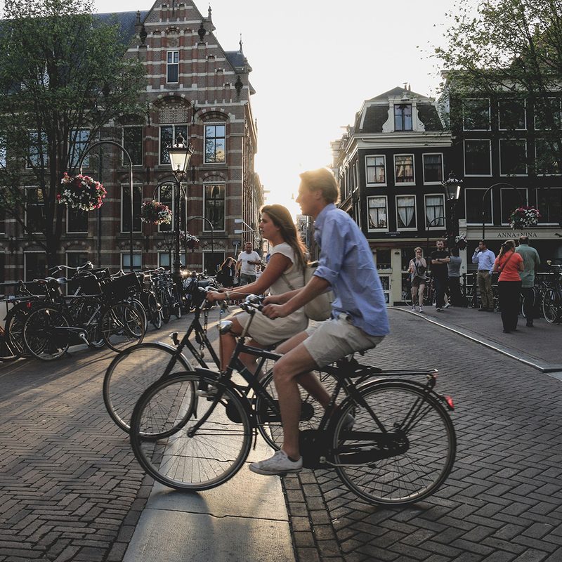 People ride their bikes in Amsterdam.