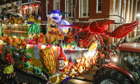 A tractor hauling a float with lobster on the street at night.
