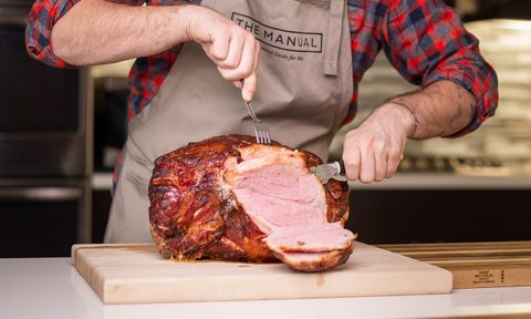 Man cutting ham in the kitchen