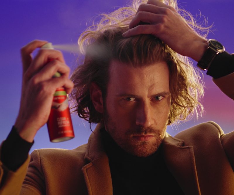 Many spraying dry shampoo in his hair