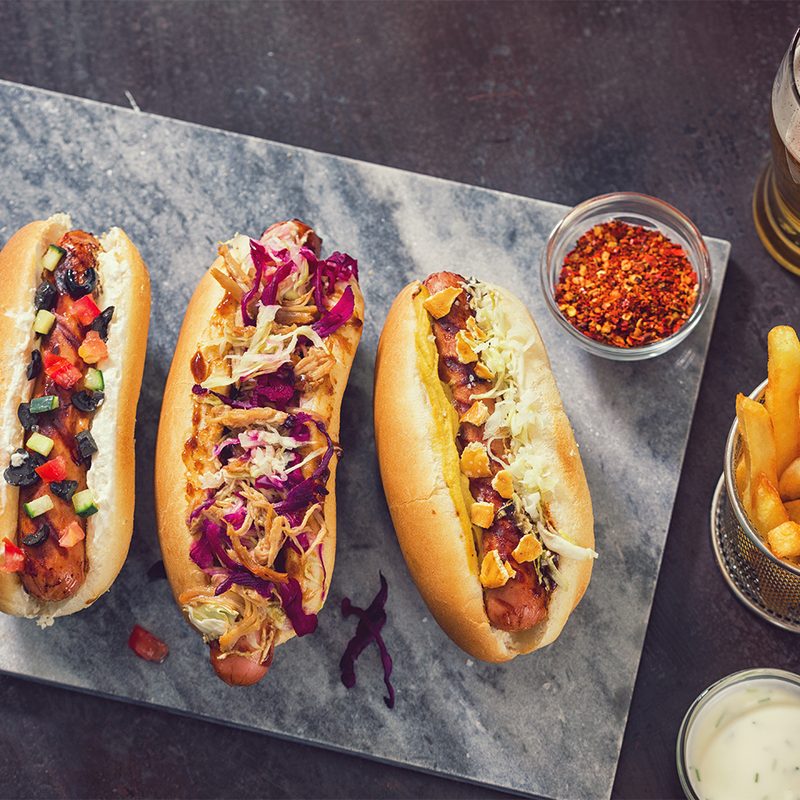 Three hot dogs with different topppings