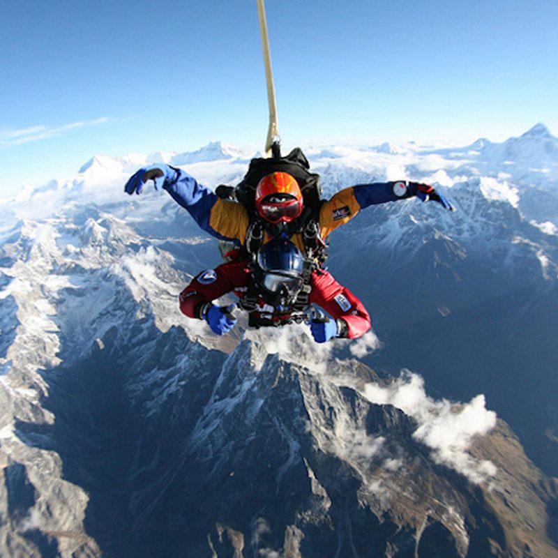 Skydivers jumping from a helicopter over Mount Everest.
